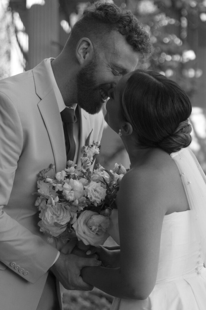 Documentary and editorial wedding photography from garden summer outdoor wedding at Eolia Mansion in Connecticut. Photos taken by Suz Lundeen Photo - destination wedding, family, and maternity photographer based in New England and the Midwest. Photo of bride and groom kissing in black and white.