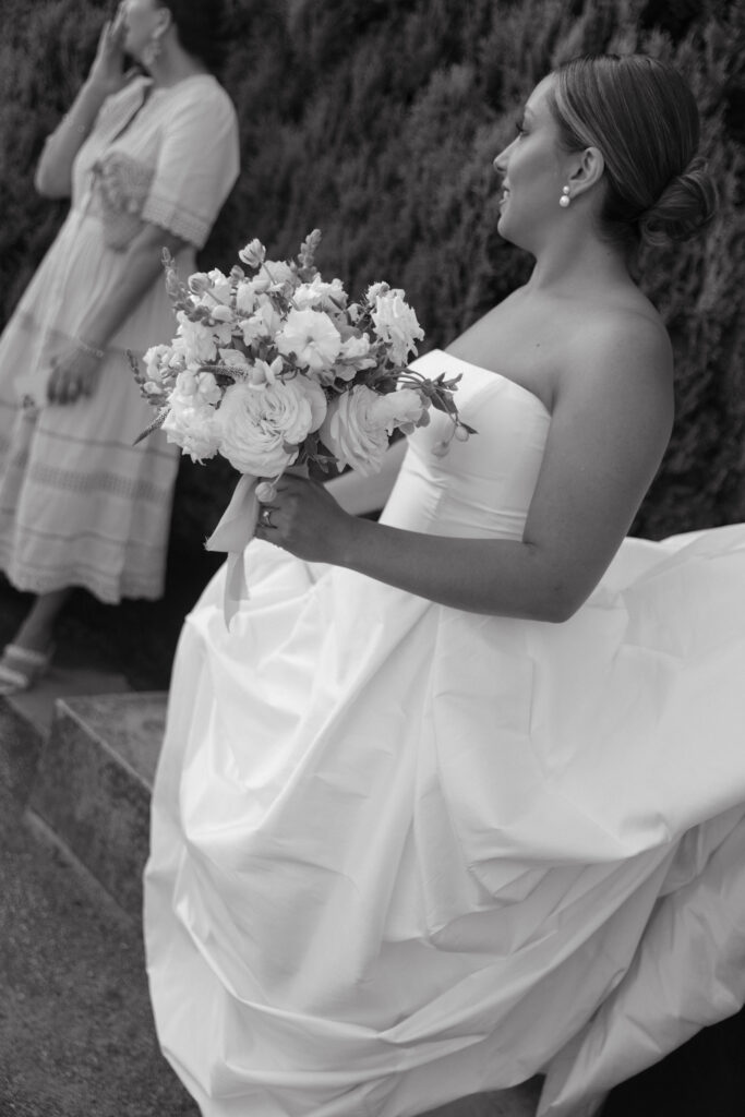 Documentary and editorial wedding photography from garden summer outdoor wedding at Eolia Mansion in Connecticut. Photos taken by Suz Lundeen Photo - destination wedding, family, and maternity photographer based in New England and the Midwest. Candid photo of bride at her garden wedding cocktail hour.