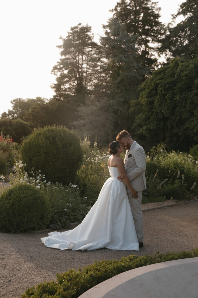 Documentary and editorial wedding photography from garden summer outdoor wedding at Eolia Mansion in Connecticut. Photos taken by Suz Lundeen Photo - destination wedding, family, and maternity photographer based in New England and the Midwest. Posed couples photo of bride and groom at sunset.